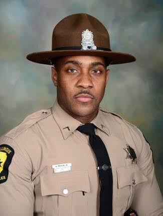 A male park ranger in uniform wearing a sheriff's badge and a brown hat with a badge insignia.