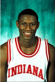 Young male basketball player in Indiana jersey smiling in front of a teal background.