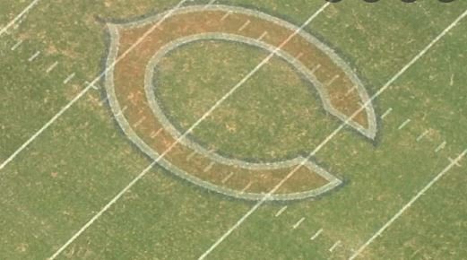Bird's eye view of a football field featuring the Cleveland Browns logo painted on the grass.