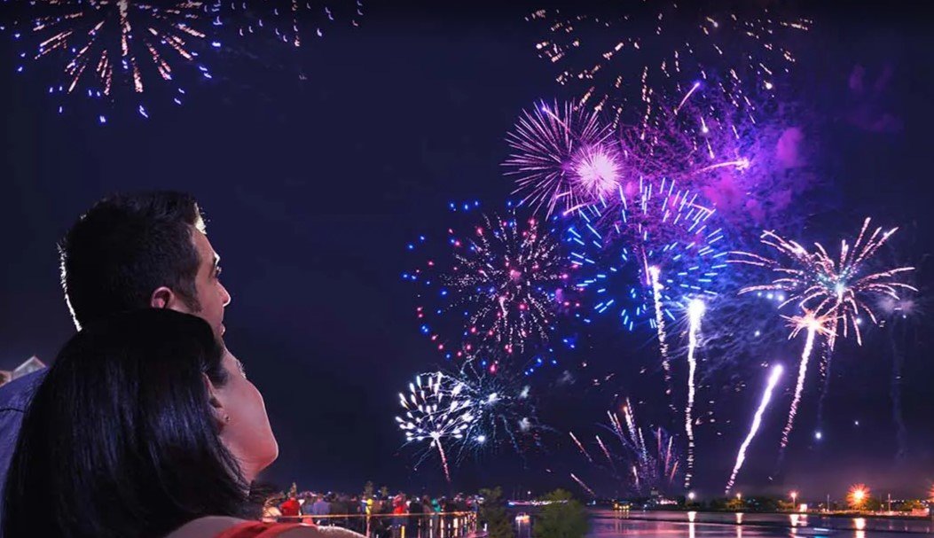 People watching fireworks display at night.