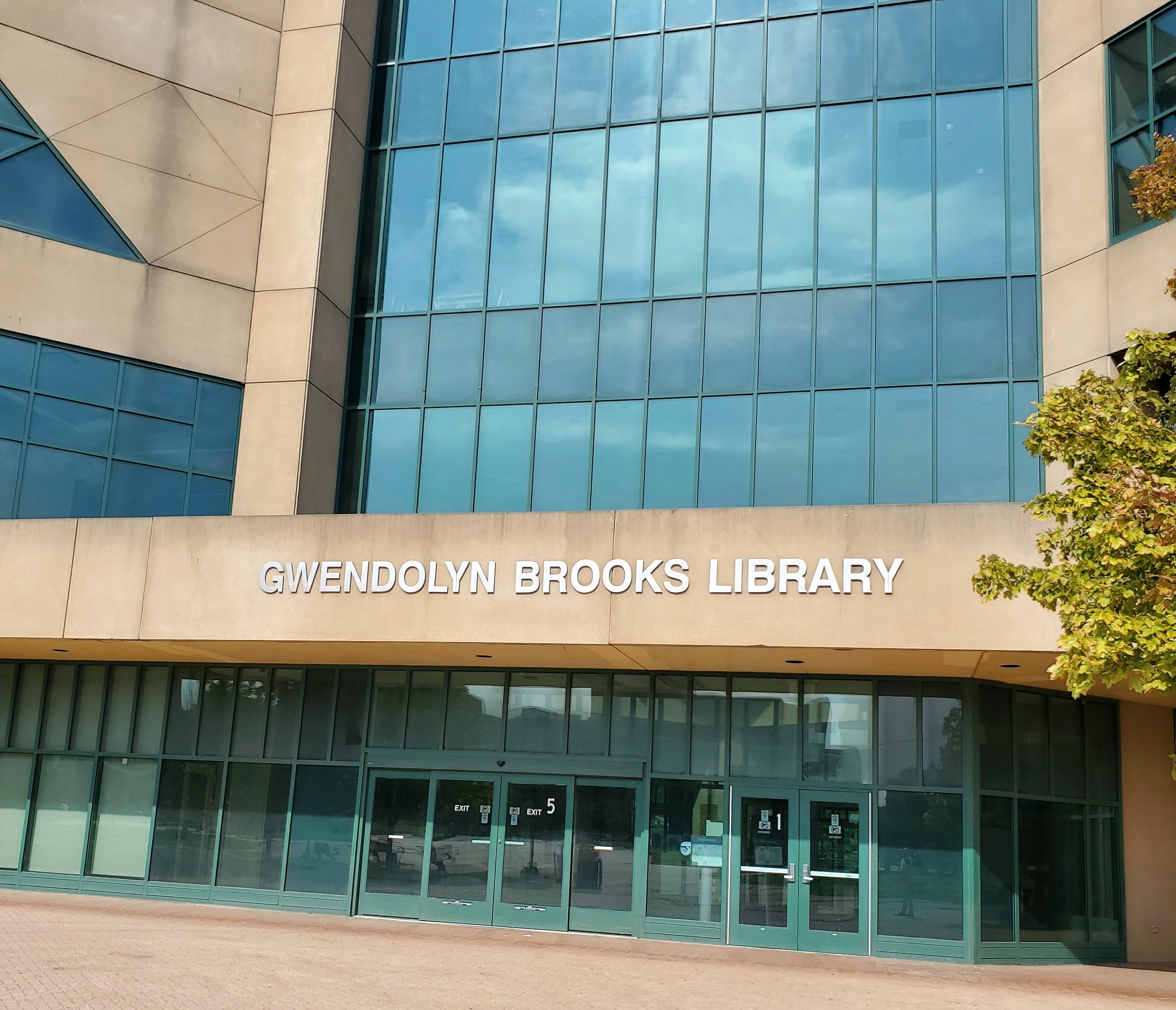 Exterior of the Gwendolyn Brooks Library building with glass windows and entrance doors.